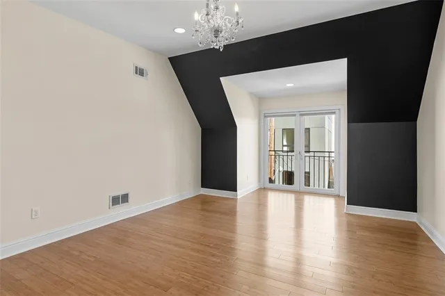 a view of a big room with wooden floor and chandelier