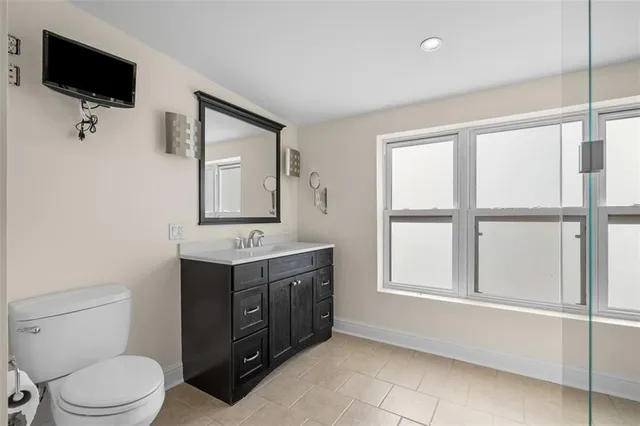 a bathroom with a toilet sink and mirror