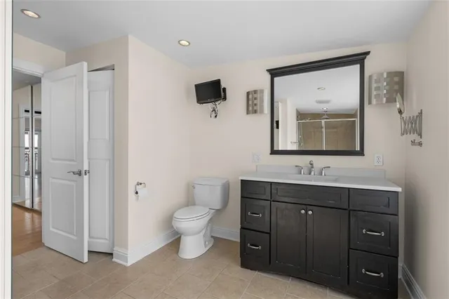 a bathroom with a toilet sink double vanity and mirror