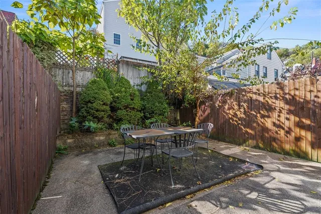 a view of a patio with table and chairs with wooden fence and plants