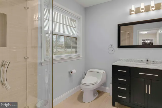 a bathroom with a toilet sink vanity and mirror