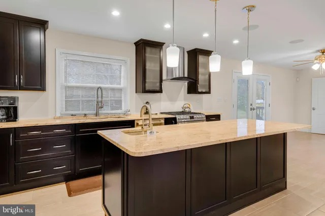 a kitchen with a sink a center island and cabinets