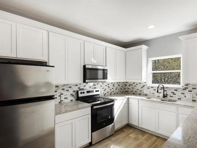a kitchen with white cabinets sink and white appliances
