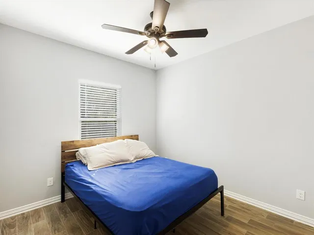 a bedroom with a bed and a ceiling fan
