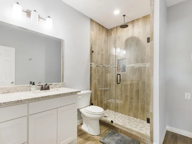a bathroom with a granite countertop sink toilet and shower