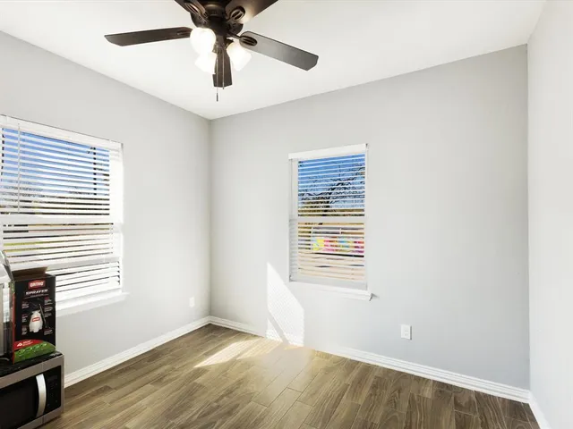 a view of an empty room with a window and a kitchen