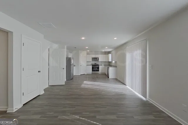 a large kitchen with stainless steel appliances granite countertop a refrigerator and a stove top oven