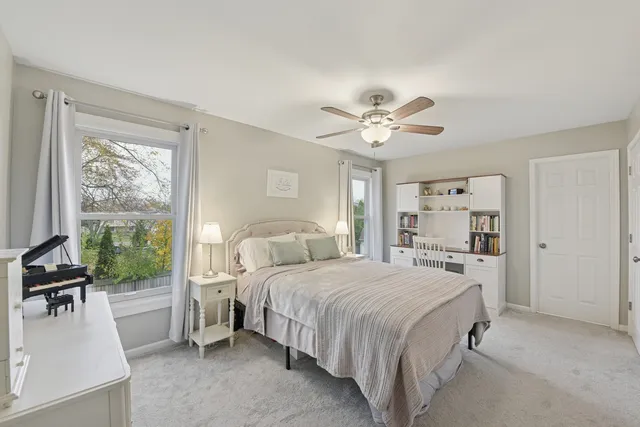 a bedroom with a bed and a large window with the outer view