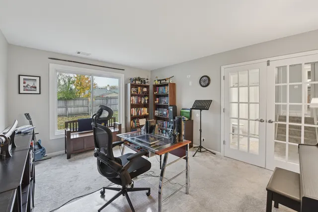 a view of a workspace with furniture and a window