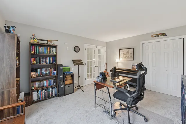 a living room with furniture a bookshelf and a window