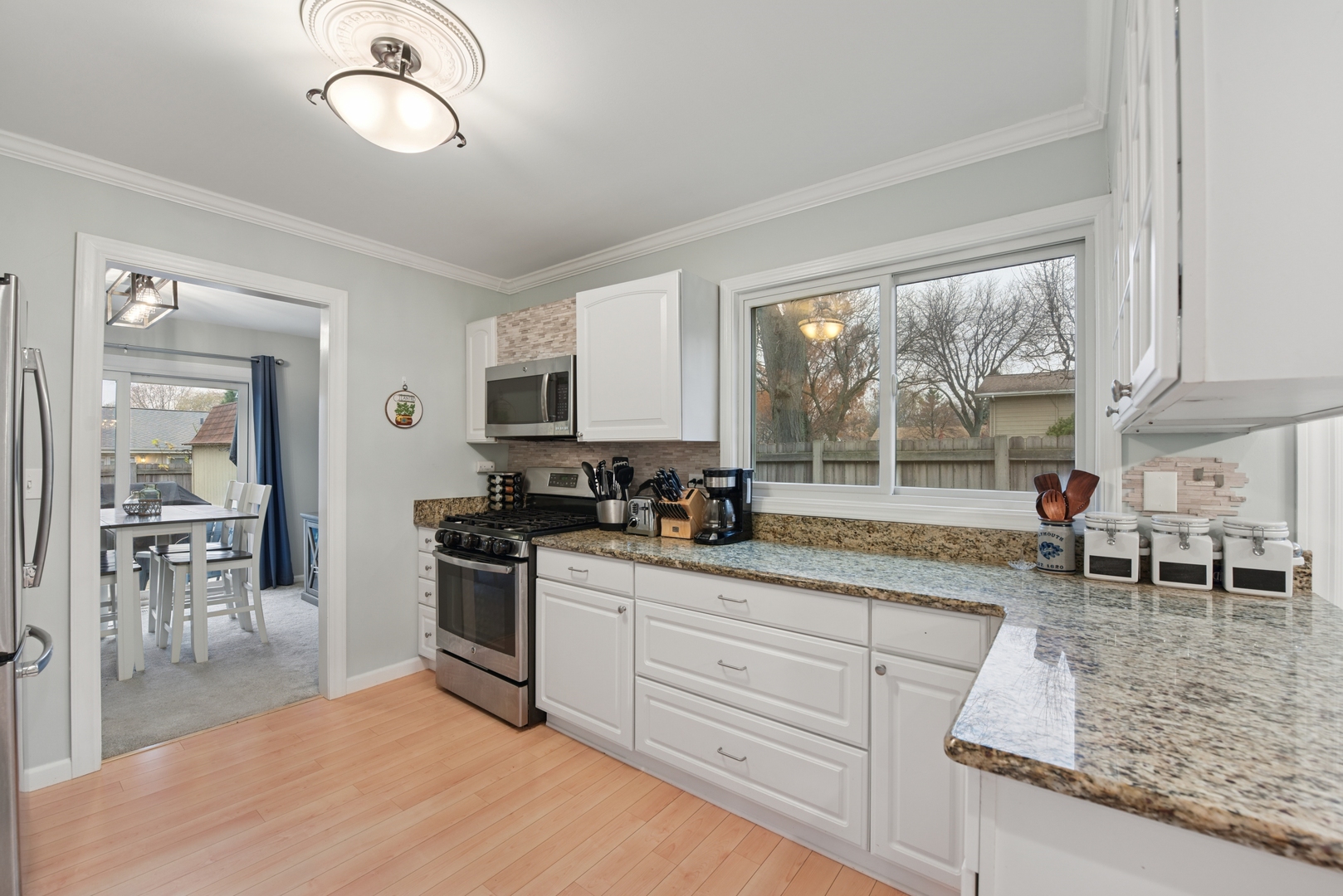 186 Ivy Lane Bloomingdale, IL 60108 - Photo 5 of 38 a kitchen with granite countertop a stove a sink a dining table and chairs