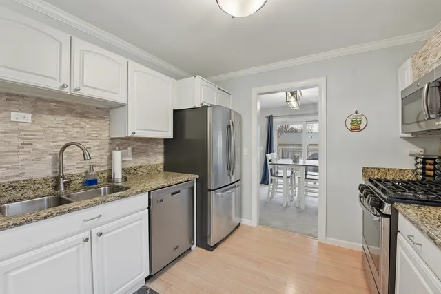 a kitchen with stainless steel appliances granite countertop a refrigerator sink and stove