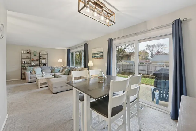a dining room with furniture a chandelier and wooden floor