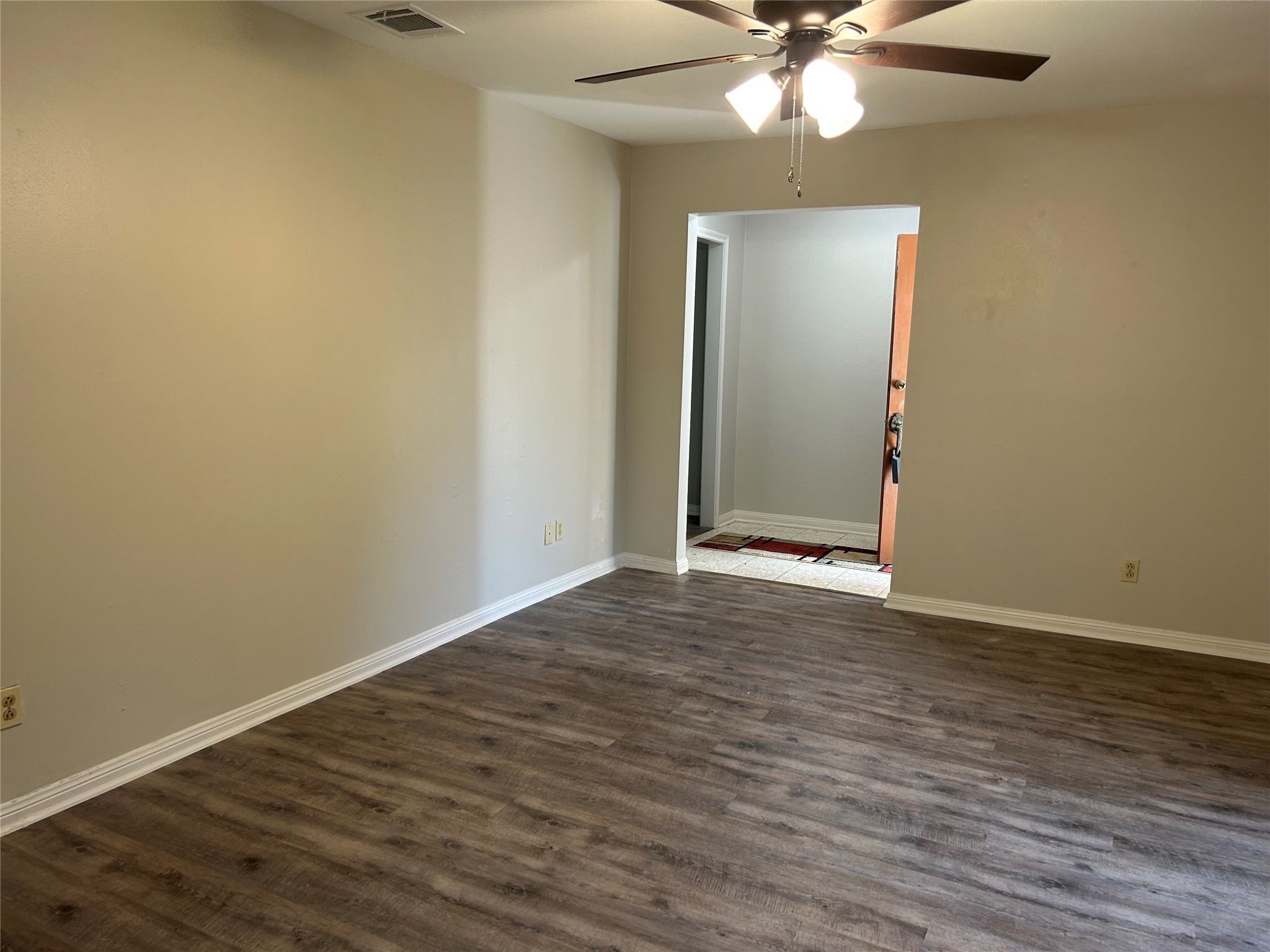 6018 Rena Street Houston, TX 77092 - Photo 6 of 28 a view of an empty room with wooden floor and a ceiling fan