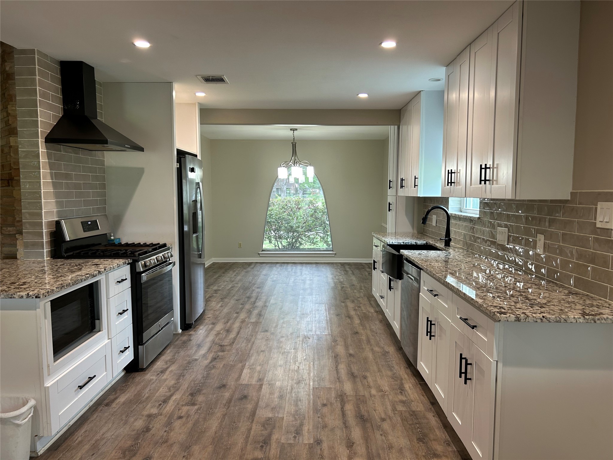 6018 Rena Street Houston, TX 77092 - Photo 10 of 28 a kitchen with stainless steel appliances granite countertop a stove a sink and a refrigerator