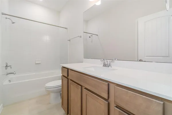 a bathroom with a granite countertop sink a toilet and bathtub