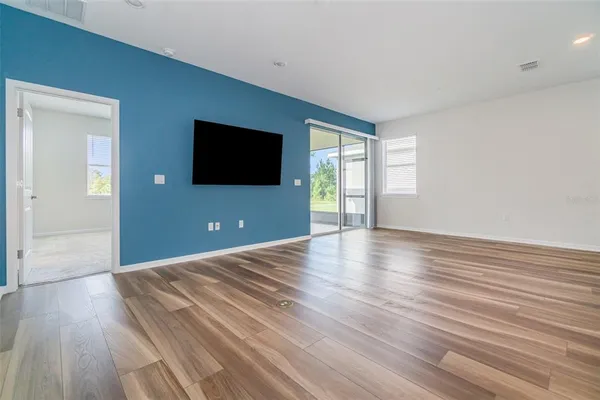 a view of a livingroom with wooden floor and a flat screen tv