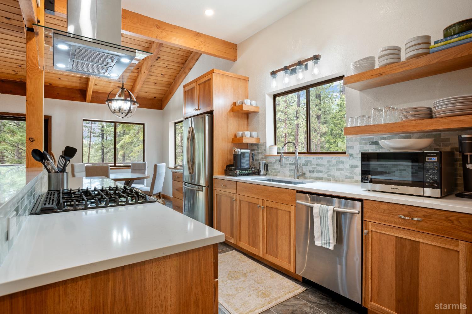 1408 Pebble Beach Road South Lake Tahoe, CA 96150 - Photo 12 of 34 a kitchen with stainless steel appliances granite countertop a sink a stove cabinets counter space and a large window