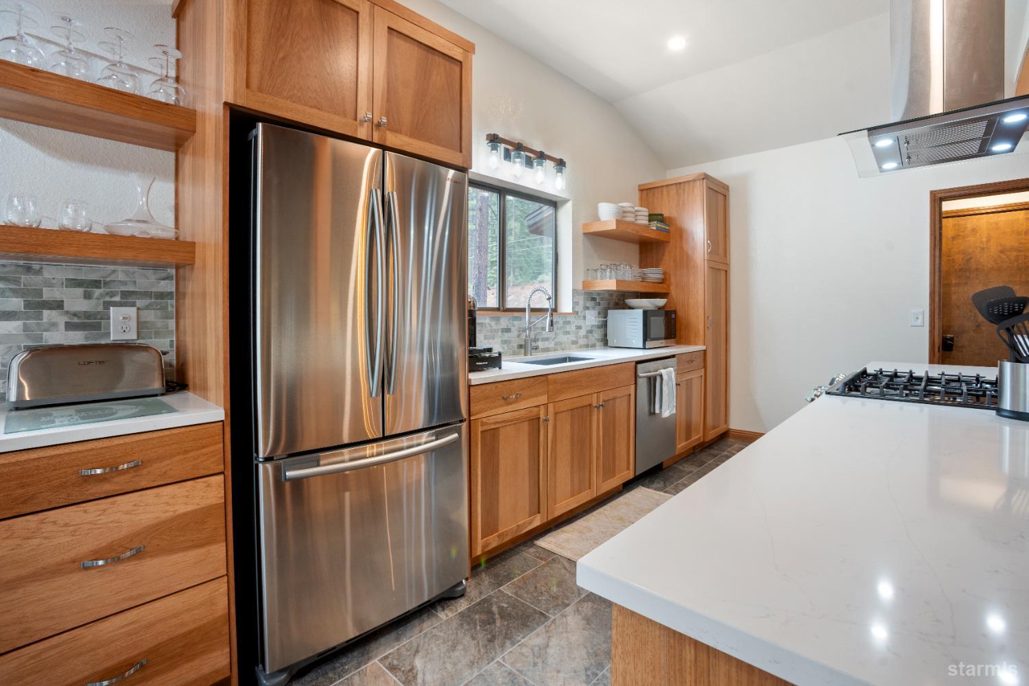 1408 Pebble Beach Road South Lake Tahoe, CA 96150 - Photo 14 of 34 a kitchen with stainless steel appliances a refrigerator and a stove top oven