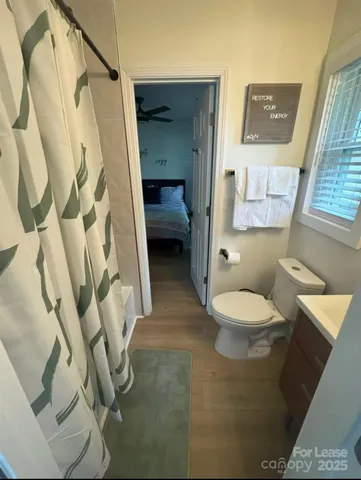 a white toilet sitting next to a shower curtain
