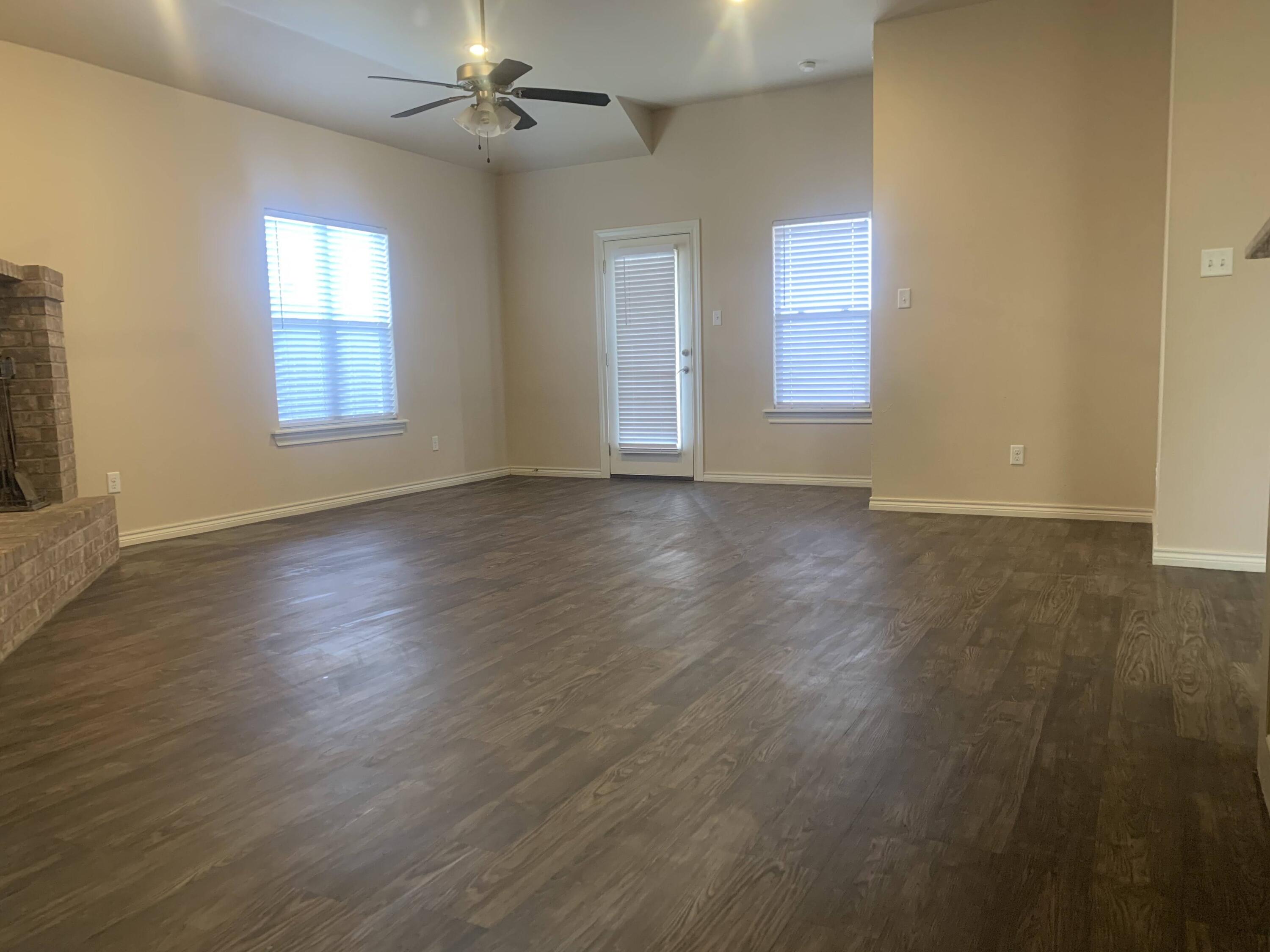 10103 Waco Avenue Lubbock, TX 79423 - Photo 11 of 14 a view of an empty room with wooden floor and a window