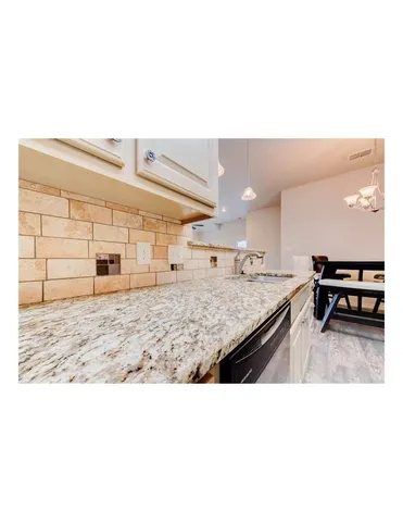 a kitchen with stainless steel appliances kitchen island granite countertop a refrigerator and a sink