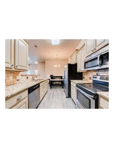 a open kitchen with stainless steel appliances granite countertop a sink stove and refrigerator