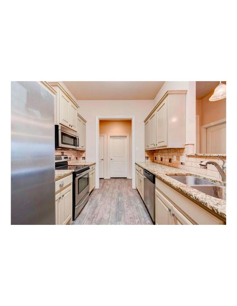 10103 Waco Avenue Lubbock, TX 79423 - Photo 10 of 14 a open kitchen with stainless steel appliances granite countertop a sink stove and refrigerator
