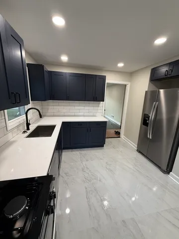 a kitchen with stainless steel appliances a sink and a refrigerator