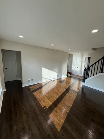 a view of an empty room with wooden floor