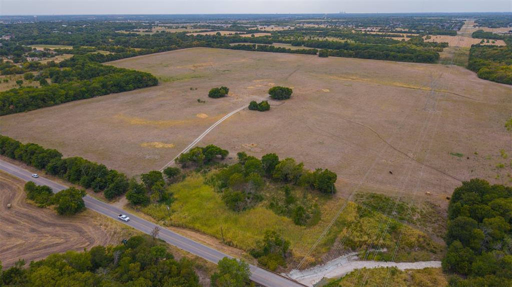 2615 South Houston School Road Lancaster, TX 75146 - Photo 13 of 15 Expansive rural landscape featuring open fields, scattered trees, and a bordering paved road
