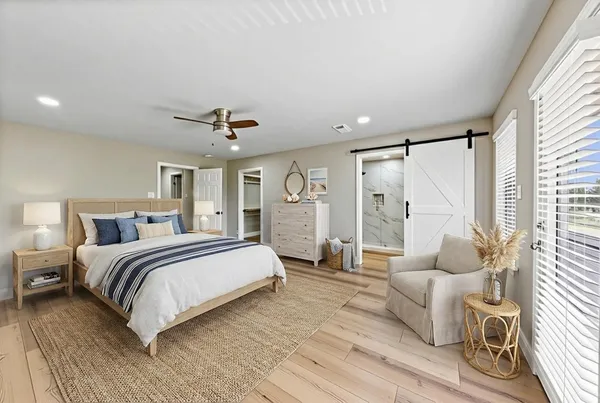 a spacious bedroom with a bed couch and a large window