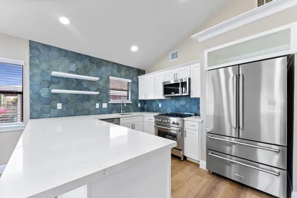 a spacious bedroom with a bed and glass walk in closet