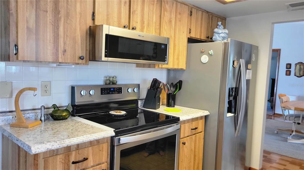 7858 Southwest 112th Lane Ocala, FL 34476 - Photo 3 of 25 a kitchen with stainless steel appliances granite countertop a stove a refrigerator and a sink