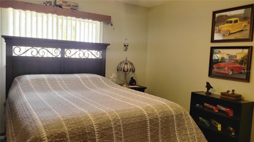 7858 Southwest 112th Lane Ocala, FL 34476 - Photo 9 of 25 a bedroom with a bed and a black furniture