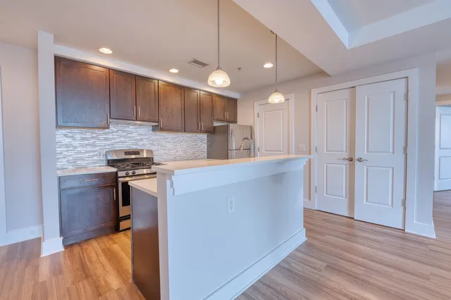 a kitchen with kitchen island granite countertop wooden cabinets and a sink