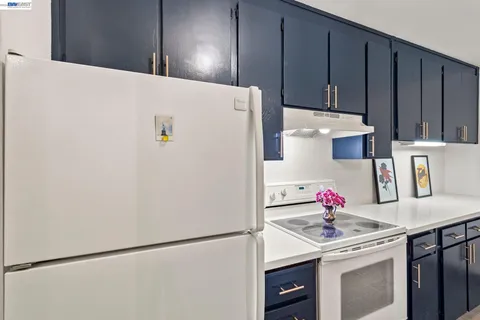 a kitchen with a stove a refrigerator and a dining table with garden view
