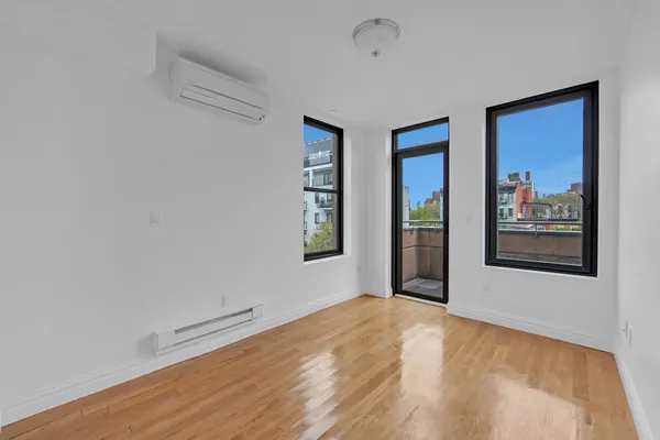 a view of a big room with wooden floor and windows