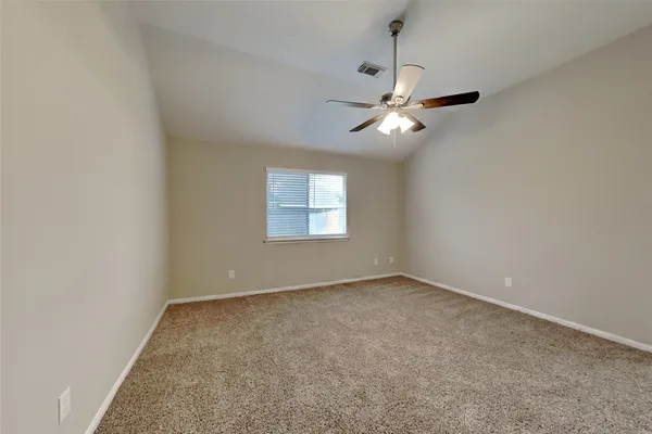 an empty room with a window and a ceiling fan