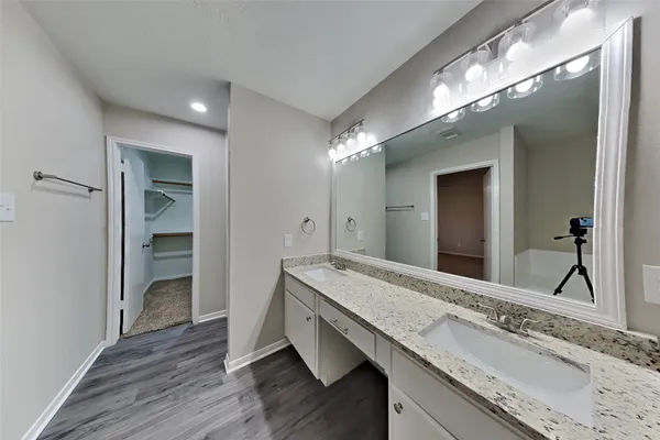 a spacious bathroom with a granite countertop sink and a mirror