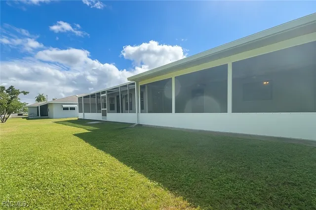 a view of backyard with swimming pool and seating space