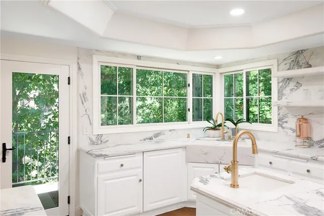 a dining room with wooden floor a chandelier a glass table and chairs