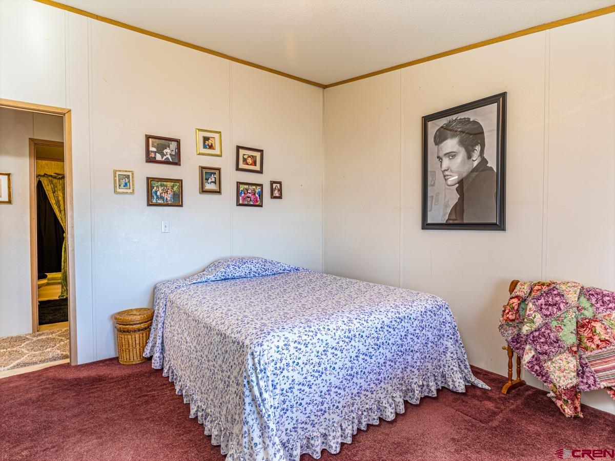 19987 Green Valley Road Cedaredge, CO 81413 - Photo 12 of 25 a bedroom with a bed and painting on the wall