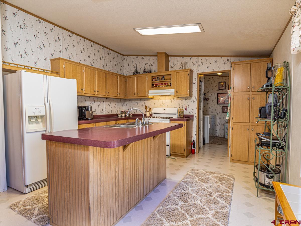 19987 Green Valley Road Cedaredge, CO 81413 - Photo 6 of 25 a kitchen with stainless steel appliances granite countertop a sink stove and refrigerator