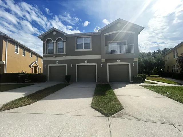 a view of a house with backyard and sitting area