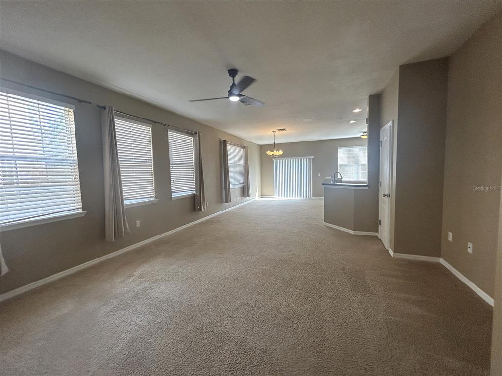 9036 Moonlit Meadows Loop Riverview, FL 33578 - Photo 6 of 20 a view of an empty room with chandelier and a kitchen