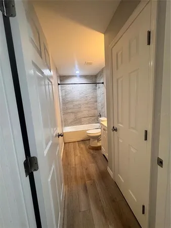 a bathroom with a granite countertop bathtub shower sink vanity and toilet