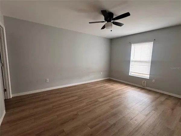 a view of a room with wooden floor and fan