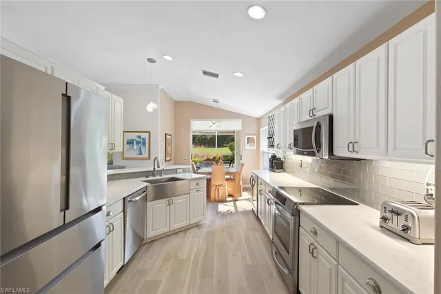 a large kitchen with stainless steel appliances lots of counter space and a sink