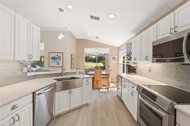 a large kitchen with stainless steel appliances lots of counter space and wooden floor
